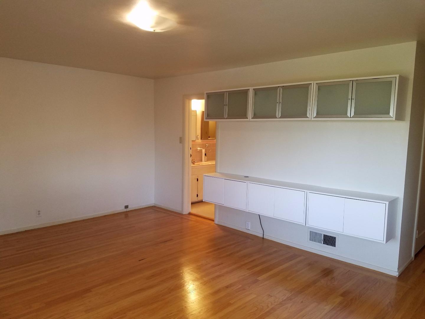 940 Black Mountain Road Hillsborough, CA 94010 - Photo 12 of 20 an empty room with wooden floor and cabinet