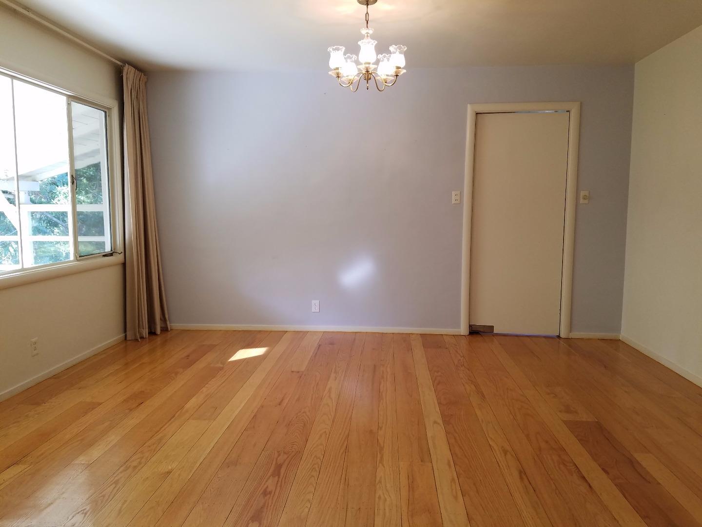 940 Black Mountain Road Hillsborough, CA 94010 - Photo 8 of 20 a view of an empty room with wooden floor and a window