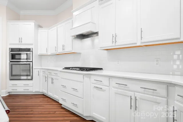 a kitchen with stainless steel appliances granite countertop a sink and a stove