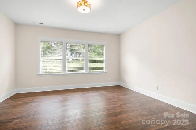 an empty room with wooden floor and a window