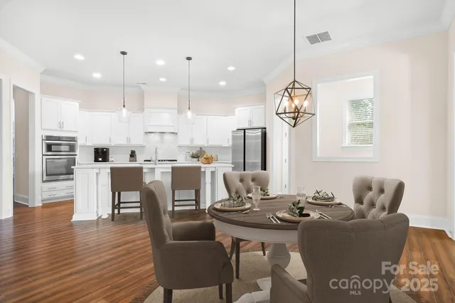 a dining room with furniture a chandelier and wooden floor