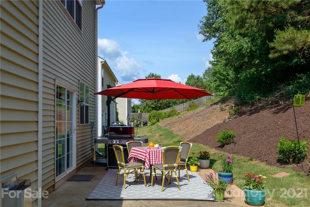 9239 Hillston Ridge Road Huntersville, NC 28078 - Photo 31 of 38 an outdoor sitting area with furniture and umbrella