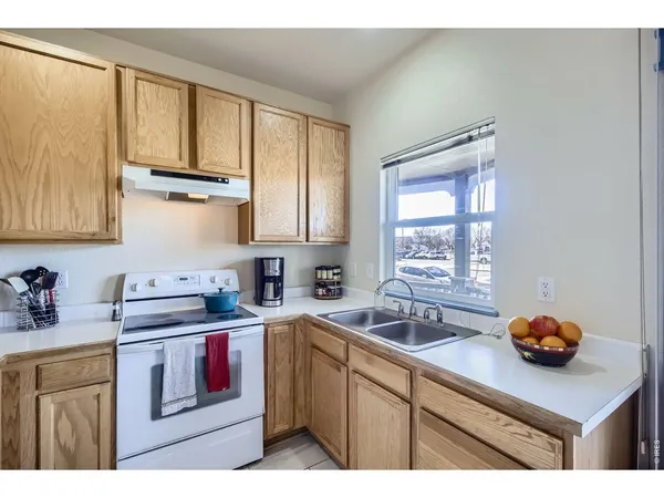 a kitchen with stainless steel appliances granite countertop white cabinets sink and window