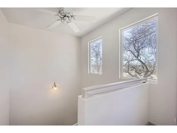 a view of a hallway with windows and chandelier fan