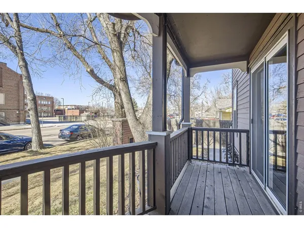 a balcony with wooden floor and outdoor seating