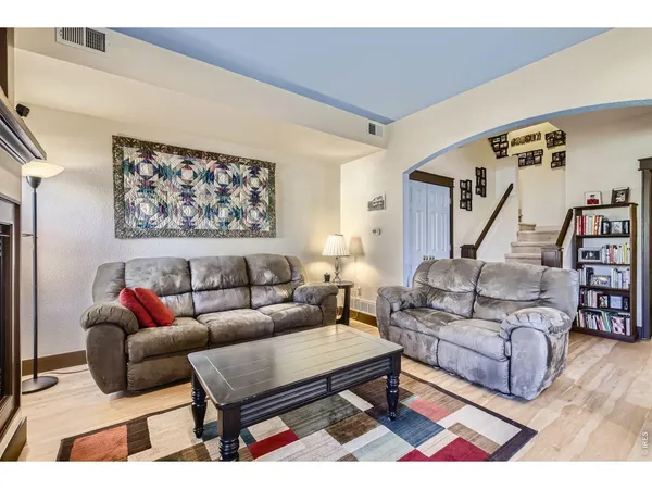 a living room with furniture a rug and a wooden floor