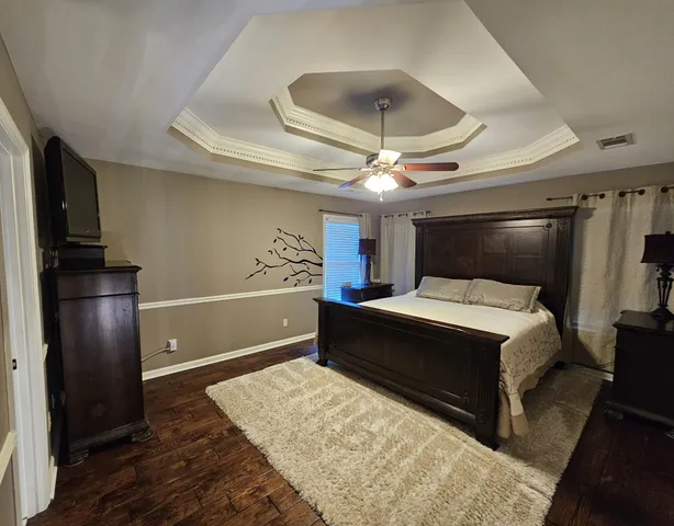 a bedroom with a large bed and a ceiling fan