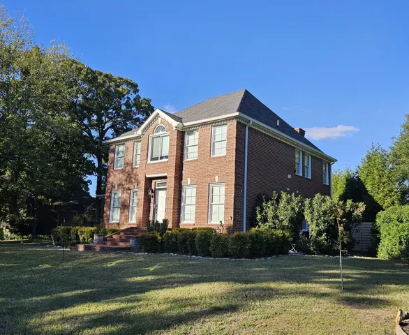 a front view of a house with a garden and plants