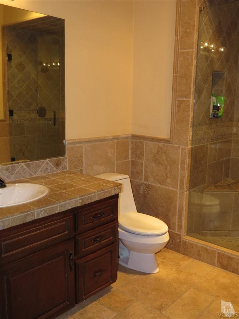 4047 Nice Court Oxnard, CA 93035 - Photo 30 of 31 a bathroom with a granite countertop sink toilet and shower