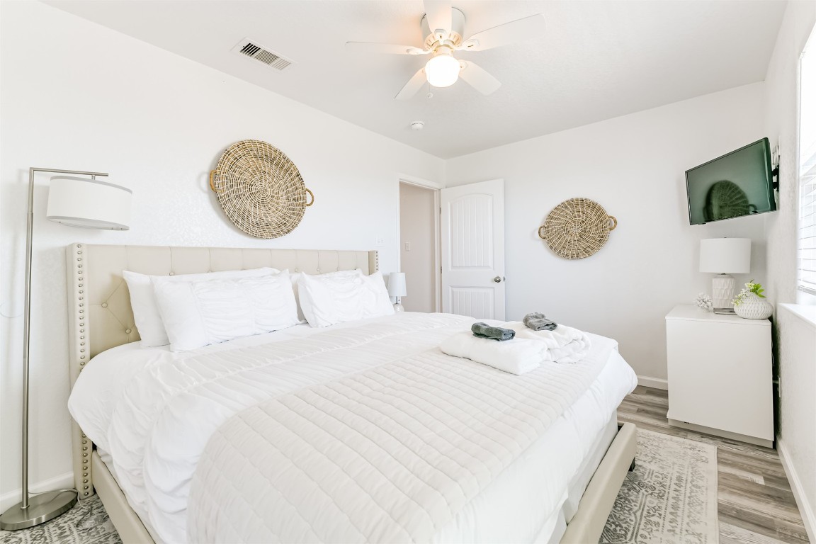 143 West Palm Surfside Beach, TX 77541 - Photo 23 of 38 a bedroom with a bed and a chandelier