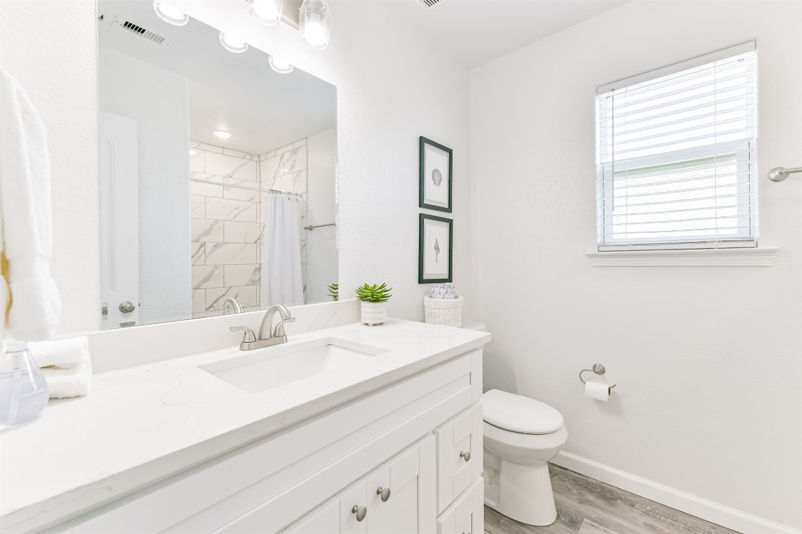143 West Palm Surfside Beach, TX 77541 - Photo 24 of 38 a bathroom with a sink a toilet and a large mirror