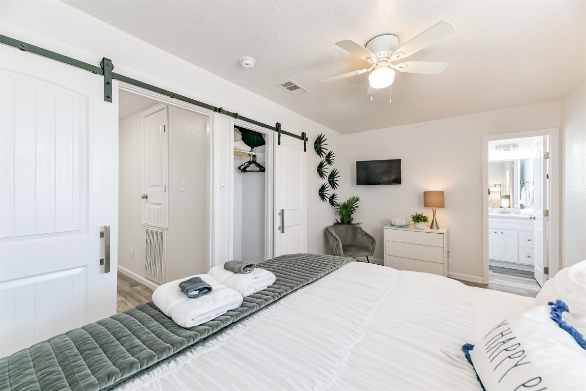 143 West Palm Surfside Beach, TX 77541 - Photo 28 of 38 a bedroom with a bed and a chandelier