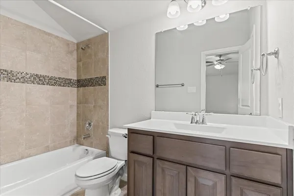 a bathroom with a sink a toilet a mirror and shower