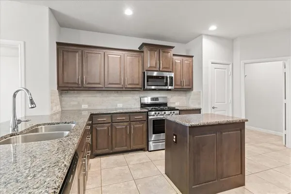 a kitchen with stainless steel appliances granite countertop a sink stove microwave and cabinets