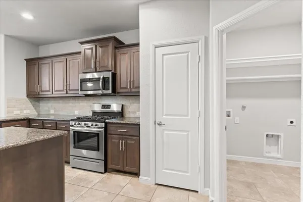 a kitchen with stainless steel appliances granite countertop white cabinets and stove top oven