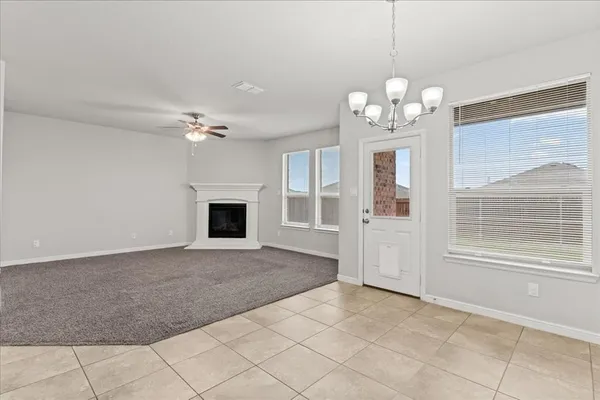 a view of a livingroom with a chandelier fan and windows