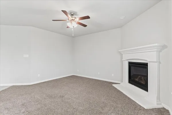 an empty room with a fireplace and fan