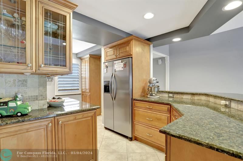 a kitchen with stainless steel appliances granite countertop a refrigerator and a sink