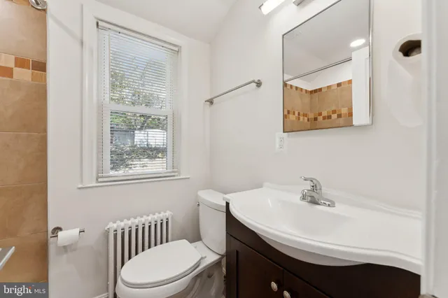 a bathroom with a sink toilet and a mirror