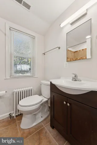 a bathroom with a sink toilet and a mirror