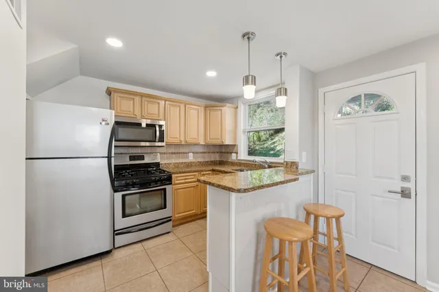 a kitchen with stainless steel appliances granite countertop a refrigerator and a stove top oven