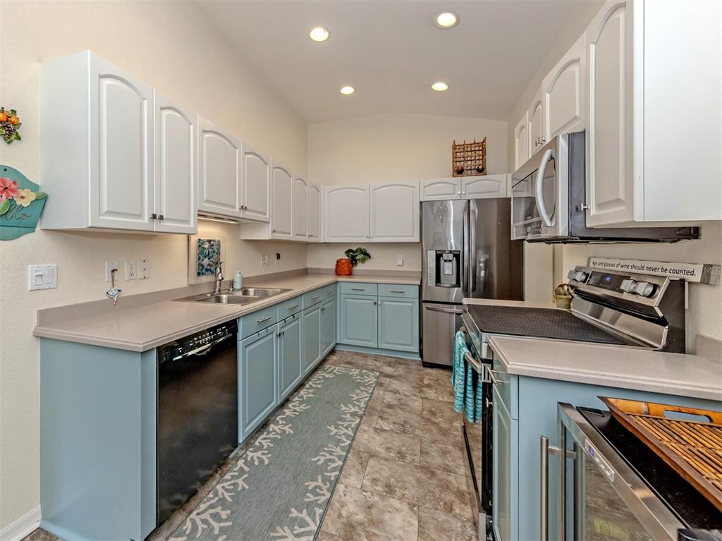 205 Reclinata Circle Venice, FL 34292 - Photo 21 of 62 a kitchen with stainless steel appliances granite countertop a sink stove and refrigerator