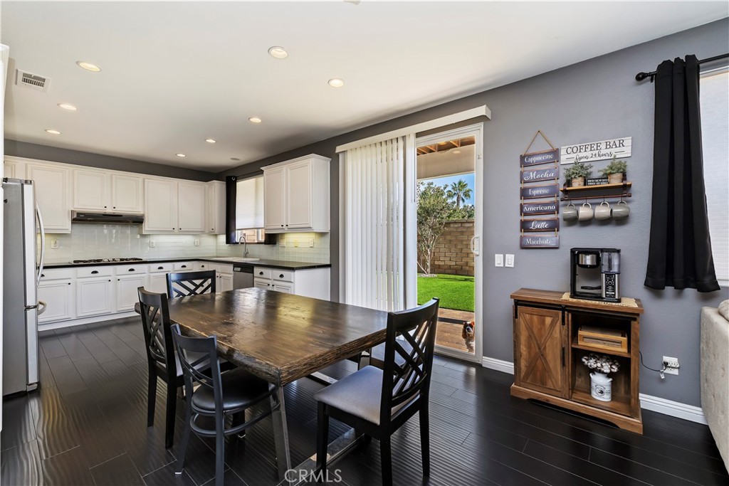 7029 Penny Court Rancho Cucamonga, CA 91739 - Photo 17 of 42 a kitchen with stainless steel appliances granite countertop a stove a refrigerator a kitchen island a table and chairs in it