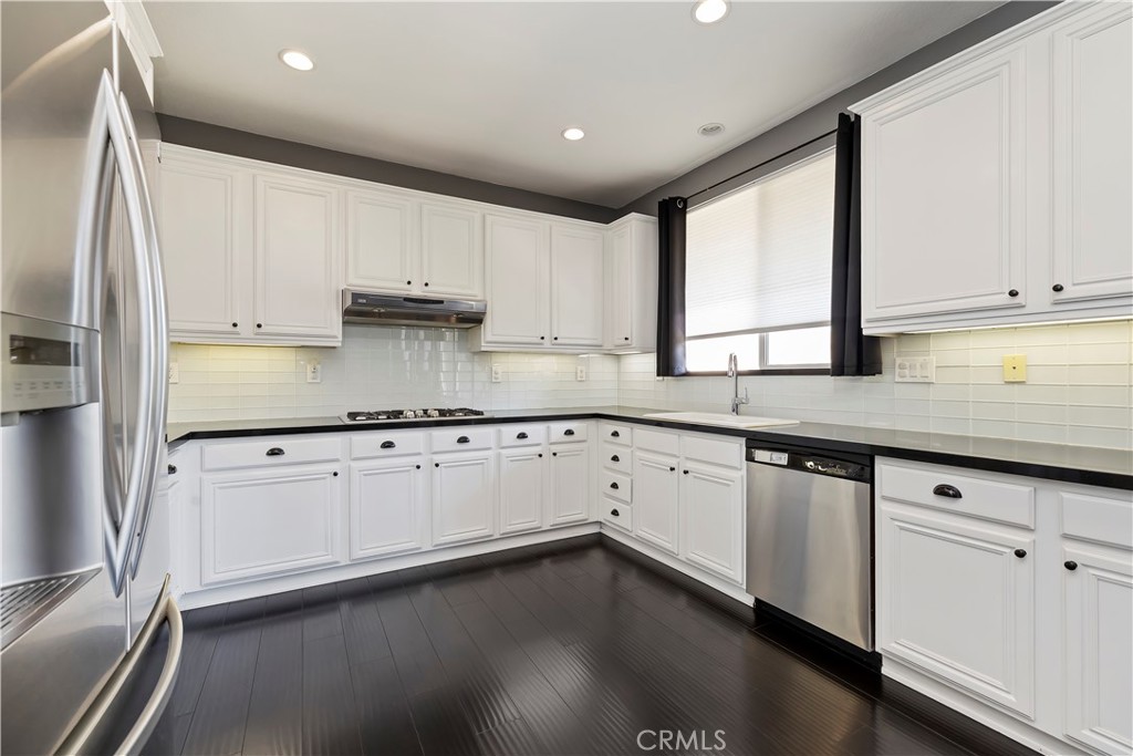 7029 Penny Court Rancho Cucamonga, CA 91739 - Photo 18 of 42 a kitchen with granite countertop white cabinets and white appliances