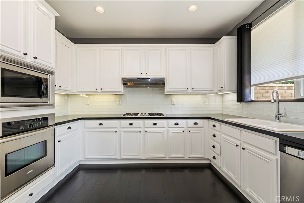 7029 Penny Court Rancho Cucamonga, CA 91739 - Photo 20 of 42 a kitchen with granite countertop white cabinets and white appliances