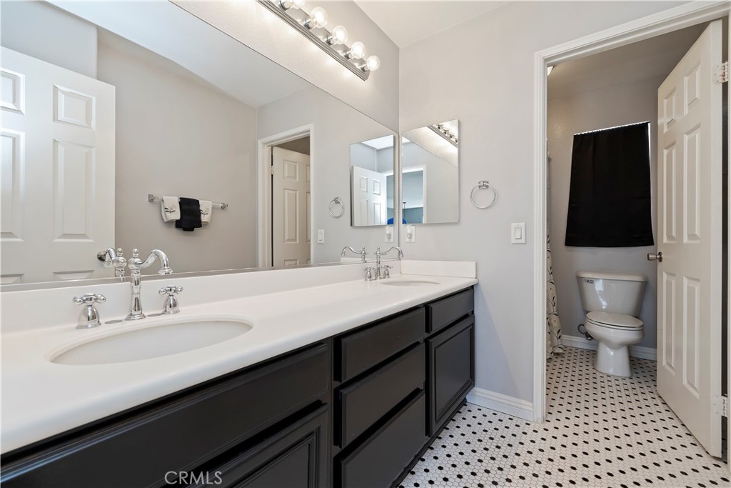 7029 Penny Court Rancho Cucamonga, CA 91739 - Photo 25 of 42 a bathroom with a sink a toilet and a large mirror