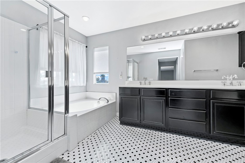 7029 Penny Court Rancho Cucamonga, CA 91739 - Photo 30 of 42 a bathroom with a bathtub sink vanity and mirror