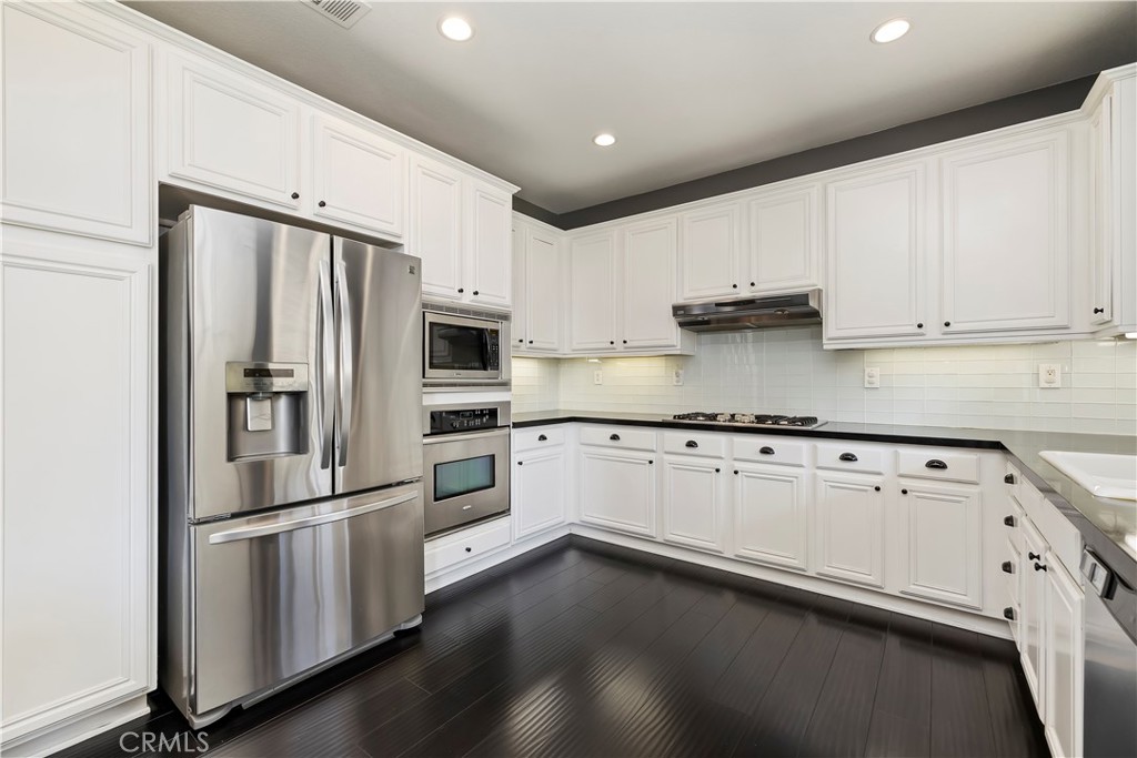 7029 Penny Court Rancho Cucamonga, CA 91739 - Photo 4 of 42 a kitchen with stainless steel appliances white cabinets and a refrigerator
