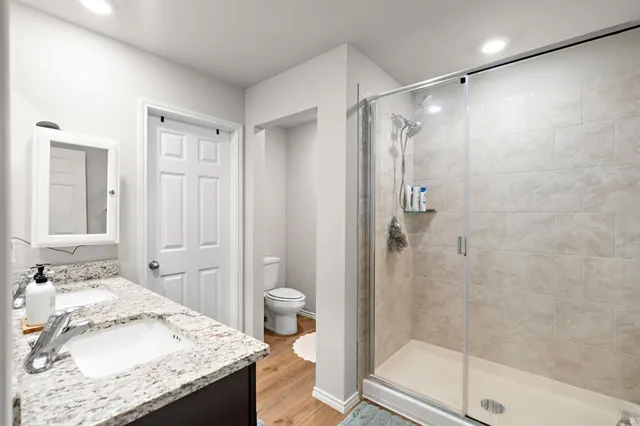 a bathroom with a granite countertop sink mirror and a shower