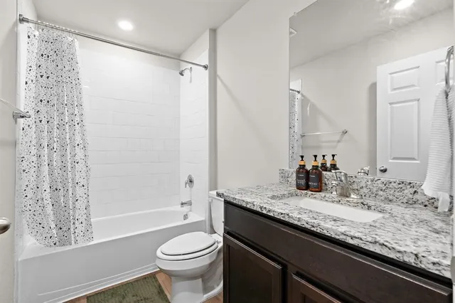 a bathroom with a granite countertop sink toilet and shower