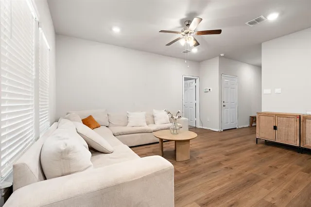 a living room with furniture and a wooden floor
