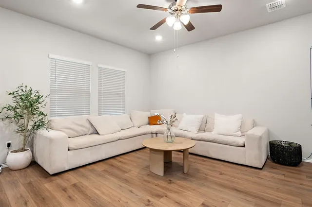 a living room with furniture and wooden floor