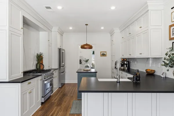 a kitchen with kitchen island granite countertop a sink and cabinets