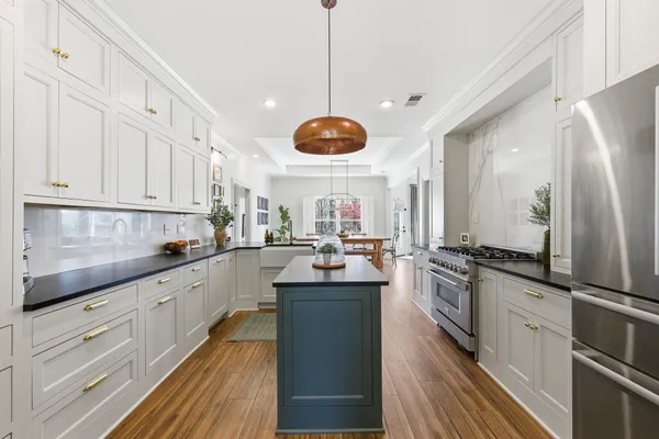 a kitchen with stainless steel appliances granite countertop sink stove refrigerator and cabinets