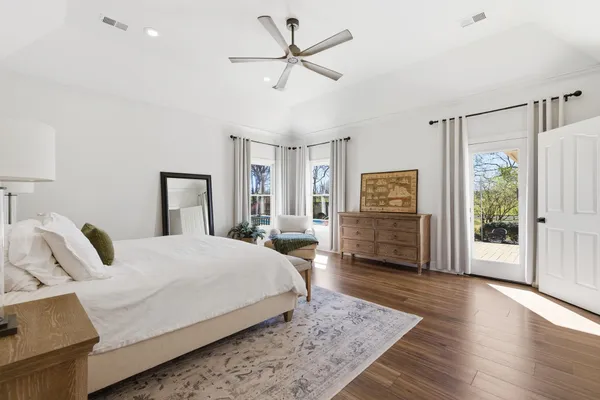 a spacious bedroom with a bed a couch and a chandelier