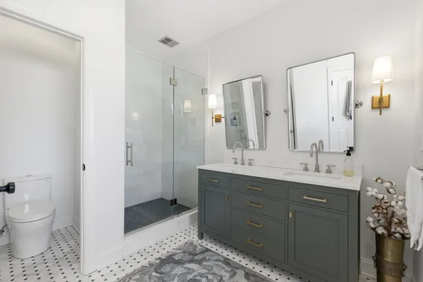 a spacious bathroom with a double vanity sink toilet and shower