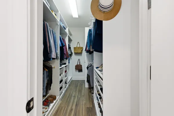 a view of walk in closet with clothes and shoes