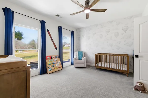 a bedroom with furniture and large windows