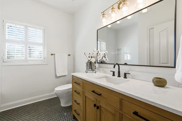 a bathroom with a sink a toilet and a mirror