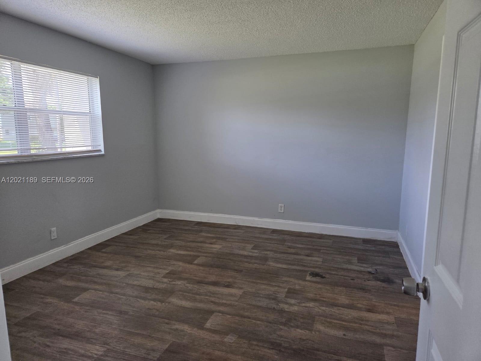 8060 North Colony Circle, Unit 103 Tamarac, FL 33321 - Photo 8 of 8 a view of a room with wooden floor and window