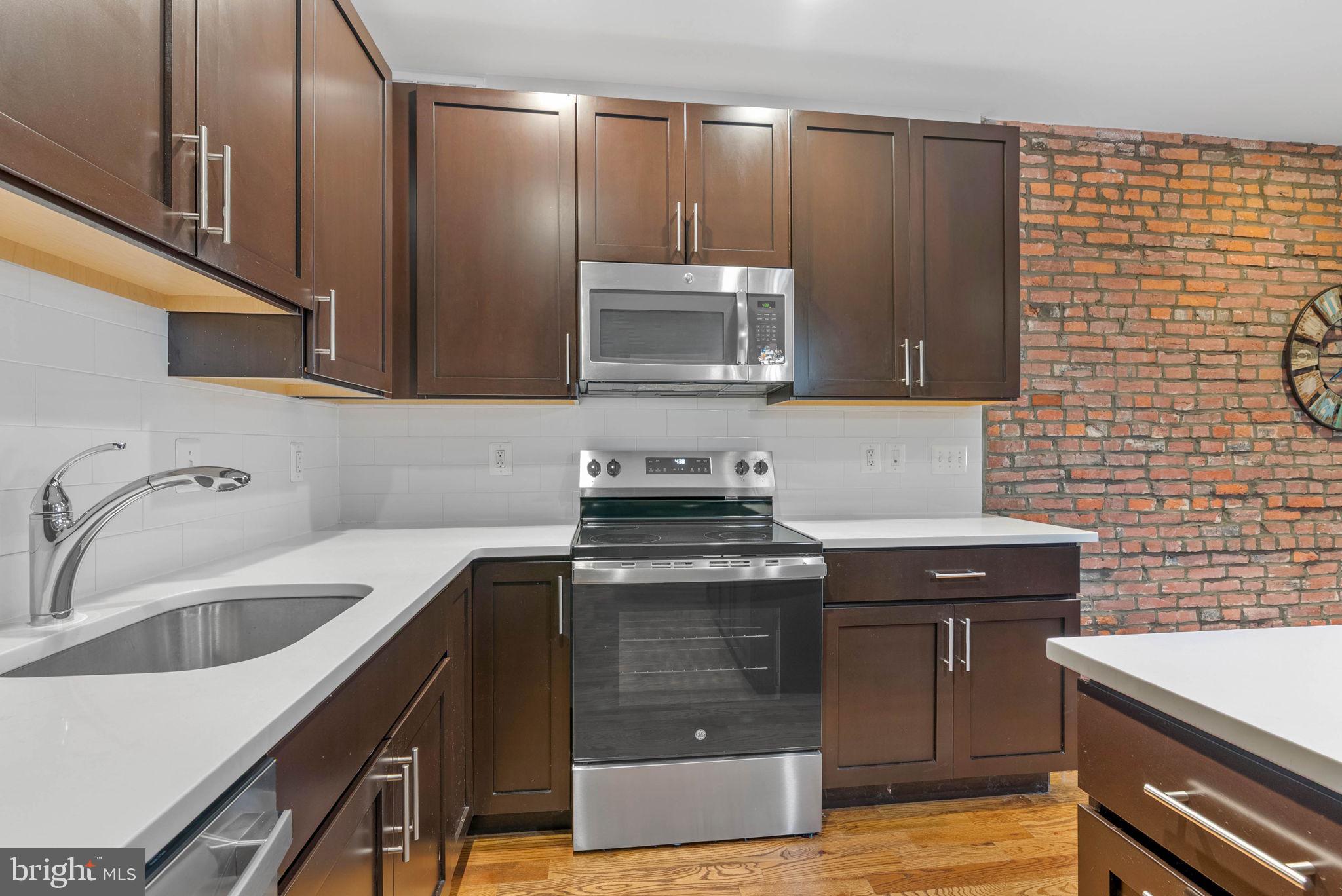 924 South 11th Street, Unit 101 Philadelphia, PA 19147 - Photo 12 of 27 a kitchen with a sink and a stove top oven