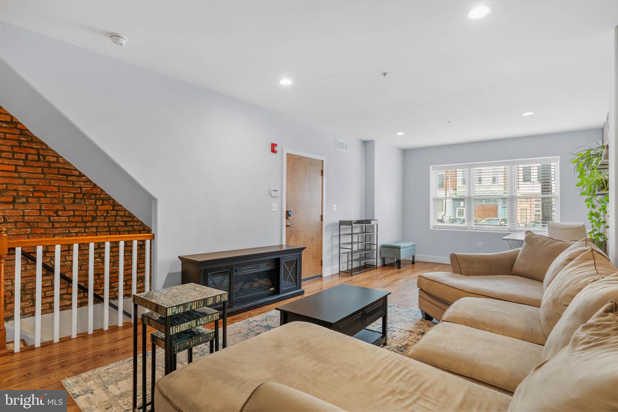 924 South 11th Street, Unit 101 Philadelphia, PA 19147 - Photo 6 of 27 a living room with furniture wooden floor and a fireplace