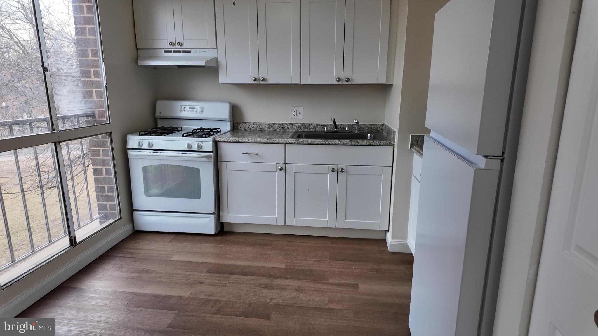 7957 Riggs Road, Unit 7 Hyattsville, MD 20783 - Photo 2 of 9 a kitchen with white cabinets and white appliances