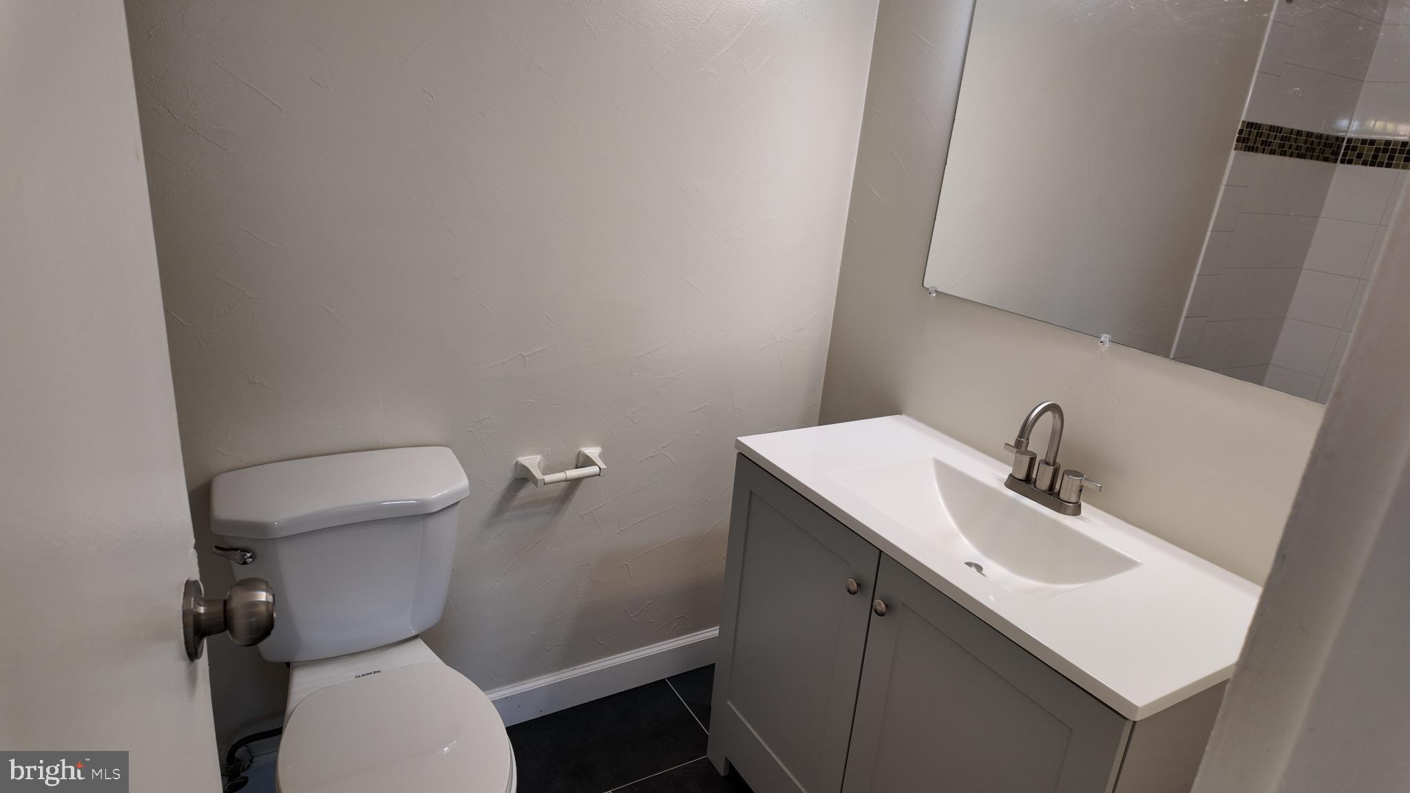7957 Riggs Road, Unit 7 Hyattsville, MD 20783 - Photo 5 of 9 a bathroom with a sink a toilet and a mirror