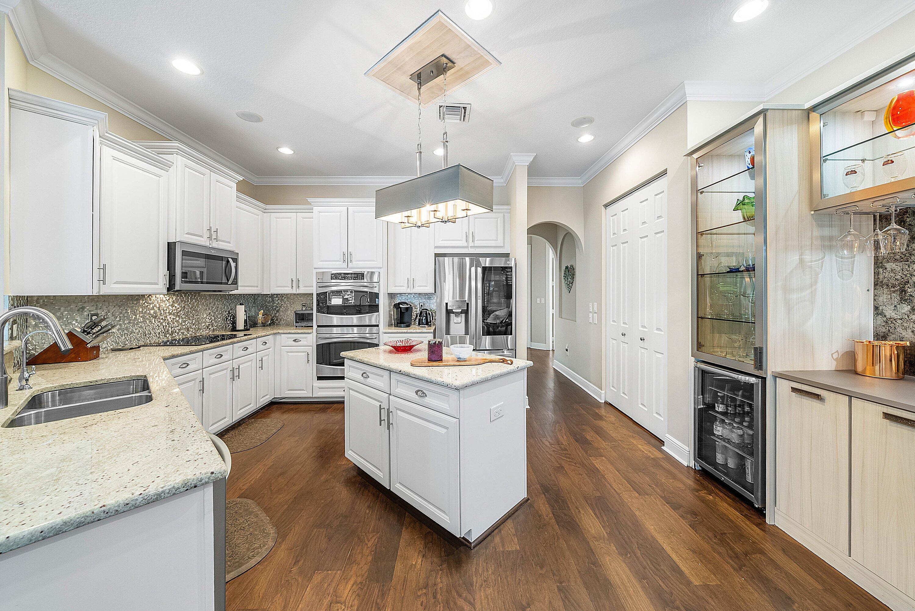 287 Rudder Cay Way Jupiter, FL 33458 - Photo 23 of 88 a kitchen with kitchen island granite countertop a sink cabinets and stainless steel appliances