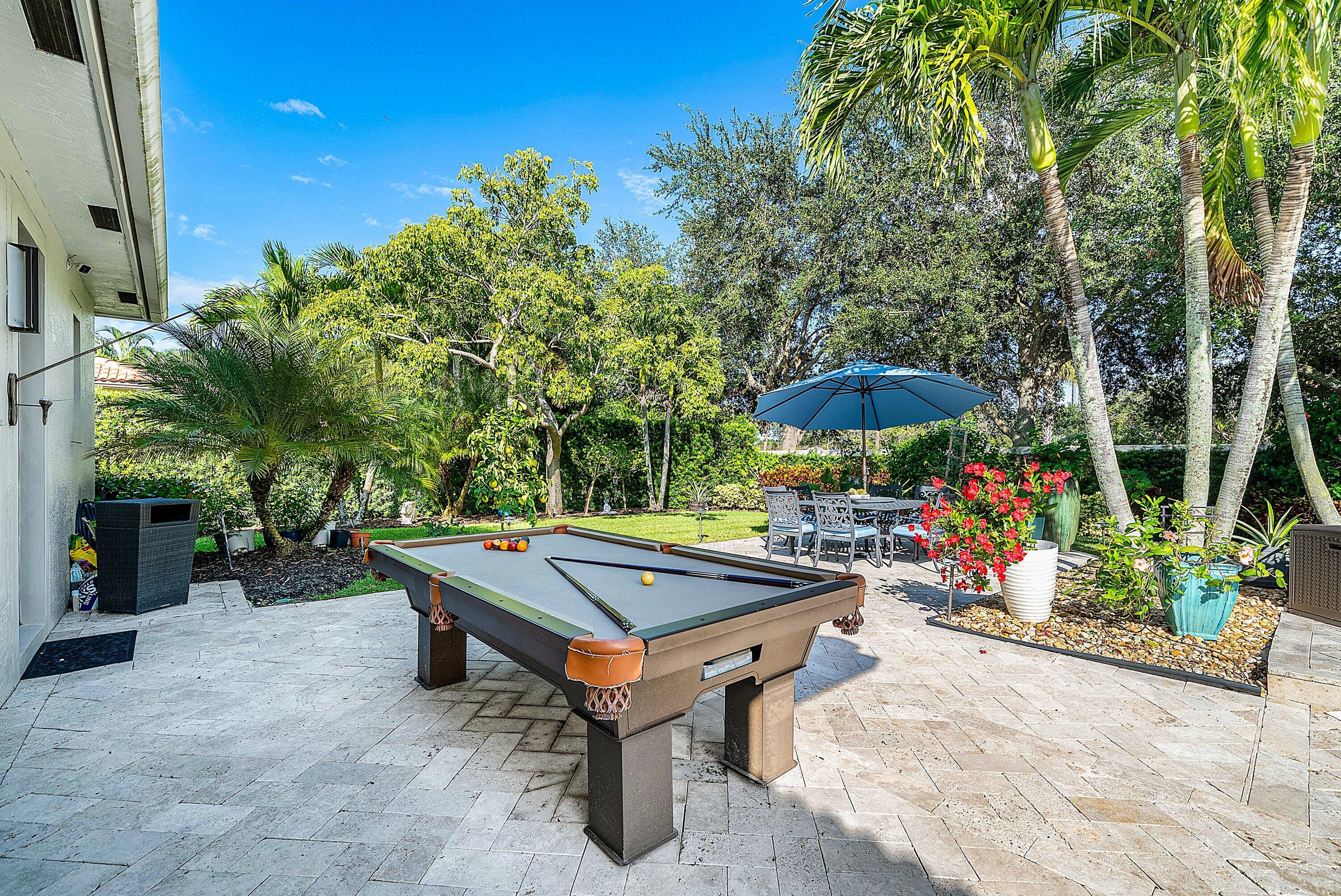 287 Rudder Cay Way Jupiter, FL 33458 - Photo 56 of 88 a view of a backyard with a table and chairs under an umbrella